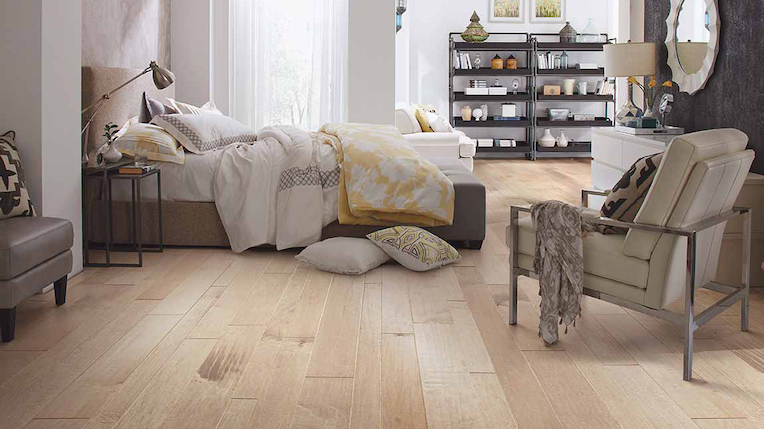 wide planked hardwood flooring in a large bright bedroom
