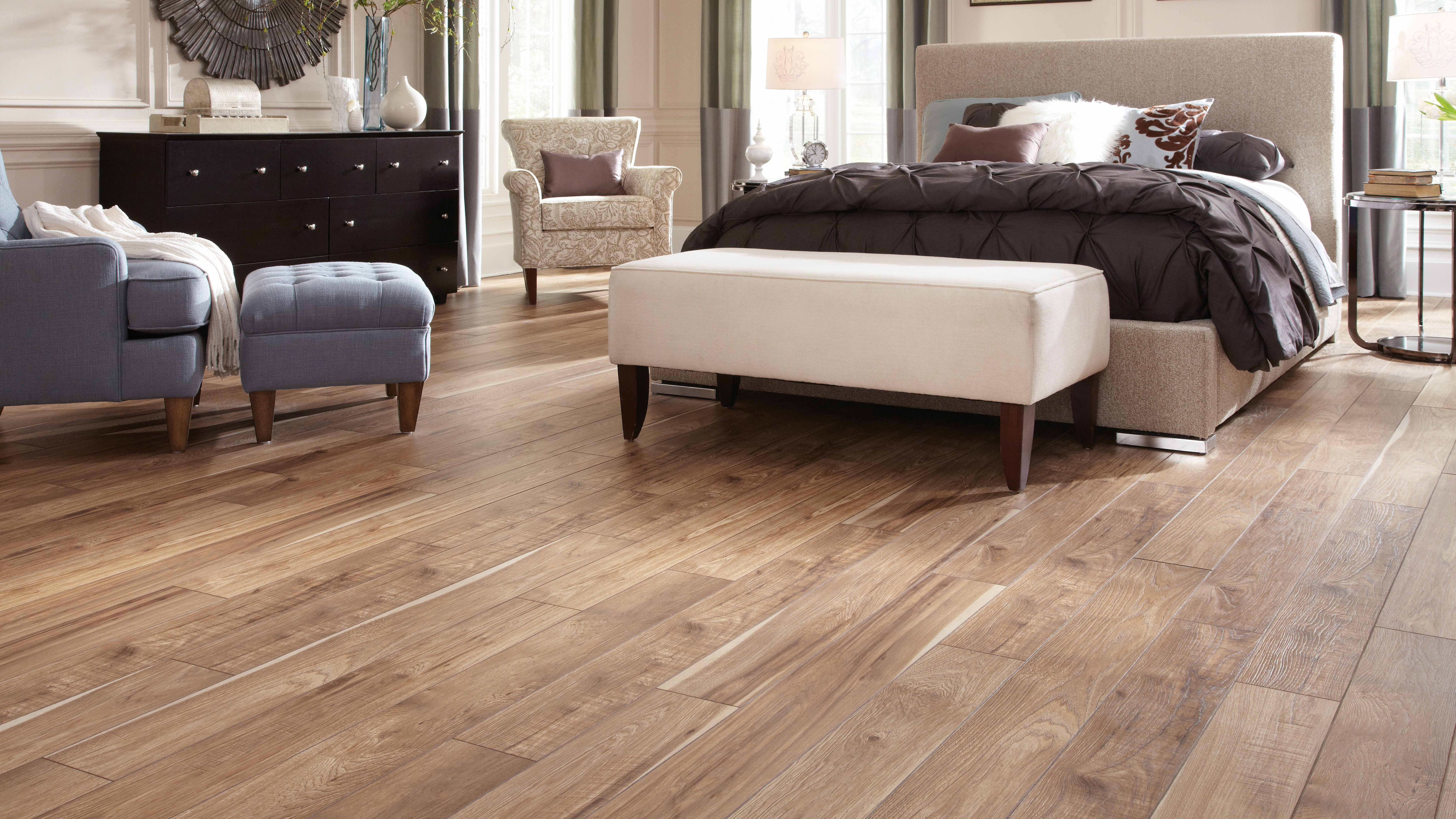 Laminate floors within a bedroom with a bedroom set and large chair 